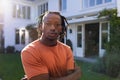 Portrait of african american man with dreadlocks standing outside house in sunny garden Royalty Free Stock Photo