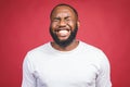 Portrait of African American man laughing isilated over red