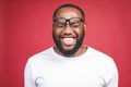 Portrait of African American man laughing isilated over red