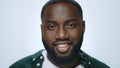 Portrait of african american man smiling on grey background in studio. Royalty Free Stock Photo