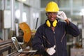 Portrait of African American mechanic engineer worker wearing safety equipment beside the sawing machine in manufacturing factory