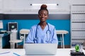 Portrait of african american nurse using laptop at white desk Royalty Free Stock Photo