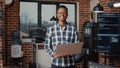 Portrait of african american programer standing working on laptop looking up and smiling