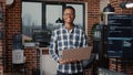 Portrait of african american programer standing working on laptop looking up and smiling