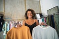 Portrait of African American seller with clothes on hangers Royalty Free Stock Photo