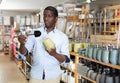 African American shopper choosing bathroom accessories in store Royalty Free Stock Photo