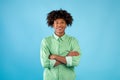 Portrait of african american teen guy with folded arms looking and smiling at camera, posing over blue background Royalty Free Stock Photo