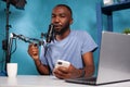 Portrait of african american vlogger holding boom arm microphone close to mouth answering messages Royalty Free Stock Photo