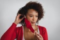 Portrait of african american woman removing face mask against grey background