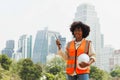 Portrait African American woman worker or engineer, African American woman worker, healthy, outdoor work. Woman holding a white Royalty Free Stock Photo