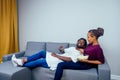 Portrait of african american young couple sitting sofa watching a movie and eating pop corn on living room Royalty Free Stock Photo