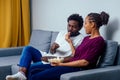 Portrait of african american young couple sitting sofa watching a movie and eating pop corn on living room Royalty Free Stock Photo