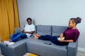 Portrait of african american young couple sitting sofa watching a movie and eating pop corn on living room Royalty Free Stock Photo