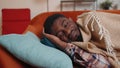 African american young man sleeping quietly in bedroom at home, smiling, lying on comfortable bed Royalty Free Stock Photo