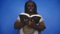 Portrait of african black man in traditional dress with rosary reading the Holy Bible Royalty Free Stock Photo