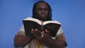 Portrait of african black man in traditional dress with rosary reading the Holy Bible Royalty Free Stock Photo