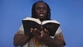 Portrait of african black man in traditional dress with rosary reading the Holy Bible Royalty Free Stock Photo