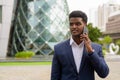 Portrait of African businessman outdoors in city talking on mobile phone Royalty Free Stock Photo