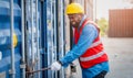 Portrait of African Engineer or foreman wears PPE checking container storage with cargo container background at sunset. Logistics Royalty Free Stock Photo