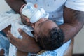 Portrait of an African father Sitting bottle-feeding his 12-day-old newborn son Royalty Free Stock Photo