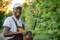 Portrait of african gardener standing near decorative hedge Royalty Free Stock Photo