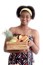 Portrait of African girl teen with curly hair wearing traditional clothes, holding tropical basket fruits. Happy smiling African Royalty Free Stock Photo