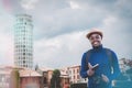 Portrait of African man backpack traveller with camera and vintage hat traveling in city.Handsome tourist man visiting Europe