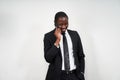 Portrait of african man smiling while talking on the phone with grey wall on background with copy space Royalty Free Stock Photo