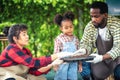 Portrait of African man and wife teaching the children to plant seedlings in greenhouse Royalty Free Stock Photo