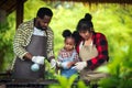 Portrait of African man and wife teaching the children to plant seedlings in greenhouse Royalty Free Stock Photo