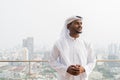 Portrait of African Muslim man wearing religious clothing an scarf at rooftop in city while thinking Royalty Free Stock Photo