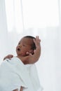 Portrait of African newborn baby boy wrapped in a blanket sleeping on motherÃ¢â¬â¢s hands on white background Royalty Free Stock Photo