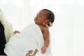 Portrait of African newborn baby boy wrapped in a blanket sleeping on motherÃ¢â¬â¢s hands on white background Royalty Free Stock Photo