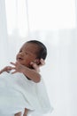 Portrait of African newborn baby boy wrapped in a blanket sleeping on motherÃ¢â¬â¢s hands on white background Royalty Free Stock Photo