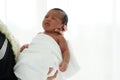 Portrait of African newborn baby boy wrapped in a blanket sleeping on motherÃ¢â¬â¢s hands on white background Royalty Free Stock Photo