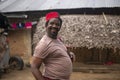 Portrait of An African Older Man in Red Muslim Taqiyyah Fez Hat posing with a stick for lame people on Yard Near the