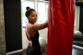 Portrait of African sports woman, attractive female boxer in black sportswear looking at camera through her shoulder, cutely Royalty Free Stock Photo