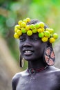 Portrait of African Teenager with a big traditional wooden earrings and wreath of dry yellow flowers on the head in the local Murs Royalty Free Stock Photo