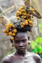 Portrait of African Teenager with a round traditional wooden earrings and Broken Horns with dry yellow flowers on the head in Murs Royalty Free Stock Photo