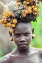 Portrait of African Teenager with a round traditional wooden earrings and Broken Horns with dry yellow flowers on the head in Murs Royalty Free Stock Photo