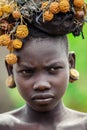 Portrait of African Teenager with a round traditional wooden earrings and Broken Horns with dry yellow flowers on the head in Murs Royalty Free Stock Photo