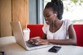 Portrait of smiling afro american female enjoying favourite playlist or listening audio language lessons in digital modern headpho Royalty Free Stock Photo