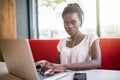 Portrait of smiling afro american female enjoying favourite playlist or listening audio language lessons in digital modern headpho Royalty Free Stock Photo