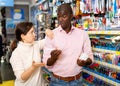 Portrait of Afro American man and Caucasian woman choosing ball pens at stationery store Royalty Free Stock Photo