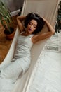 Portrait of Afro-American pretty young woman in cozy apartment with home plants, beutiful curly black woman with bright Royalty Free Stock Photo