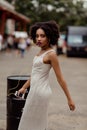 Portrait of Afro-American pretty young woman on the street, she looks at the camera and listen music , beutiful curly Royalty Free Stock Photo