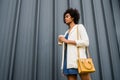 Portrait of afro business woman walking outdoors.