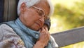 Portrait of aged Caucasian woman with glasses holding hand of her husband and closing eyes copy space park background Royalty Free Stock Photo