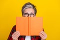 Portrait of aged lady hands hold book cover face eyes peek watch empty space ad isolated on yellow color background