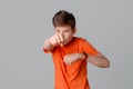 Portrait of aggressive teenager boy, clenched his hands into fists, feeling furious wearing casual pink t shirt standing over gray Royalty Free Stock Photo